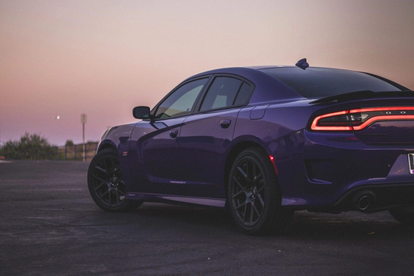 A purple car is parked on the side of the road.